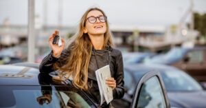 Woman holding car keys next to a rental car
