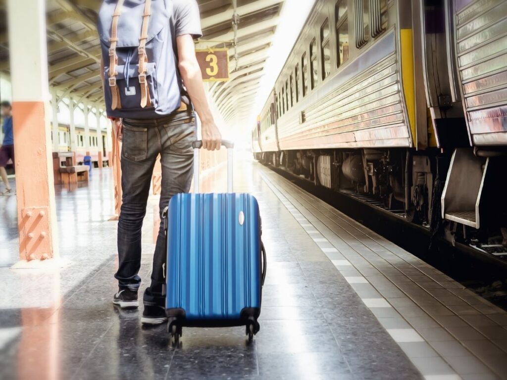 Confused traveler with large suitcase at a European train station