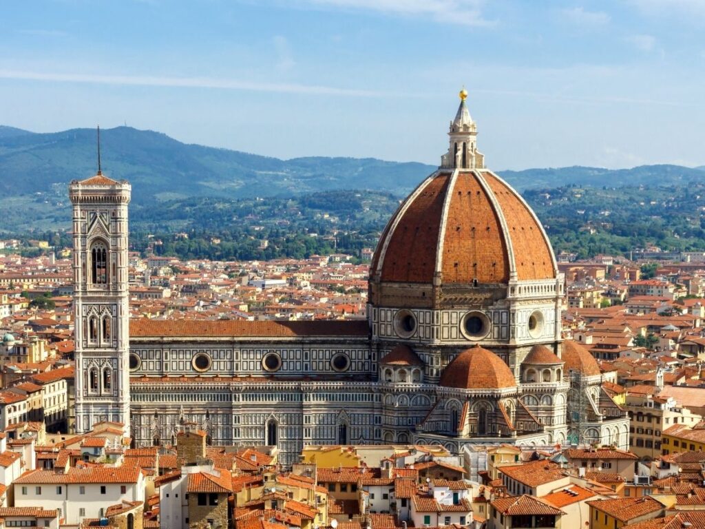 View of Florence’s Duomo and red rooftops from above on a sunny day