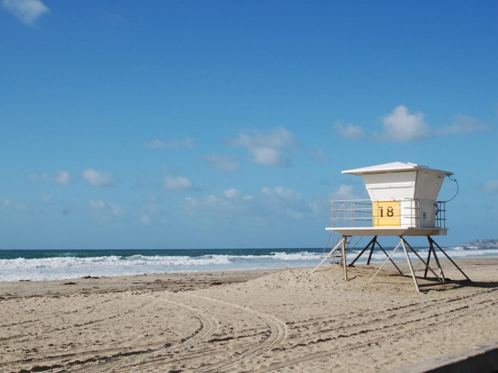 Lifeguard tower overlooking Hapuna Beach with swimmers in calm morning water