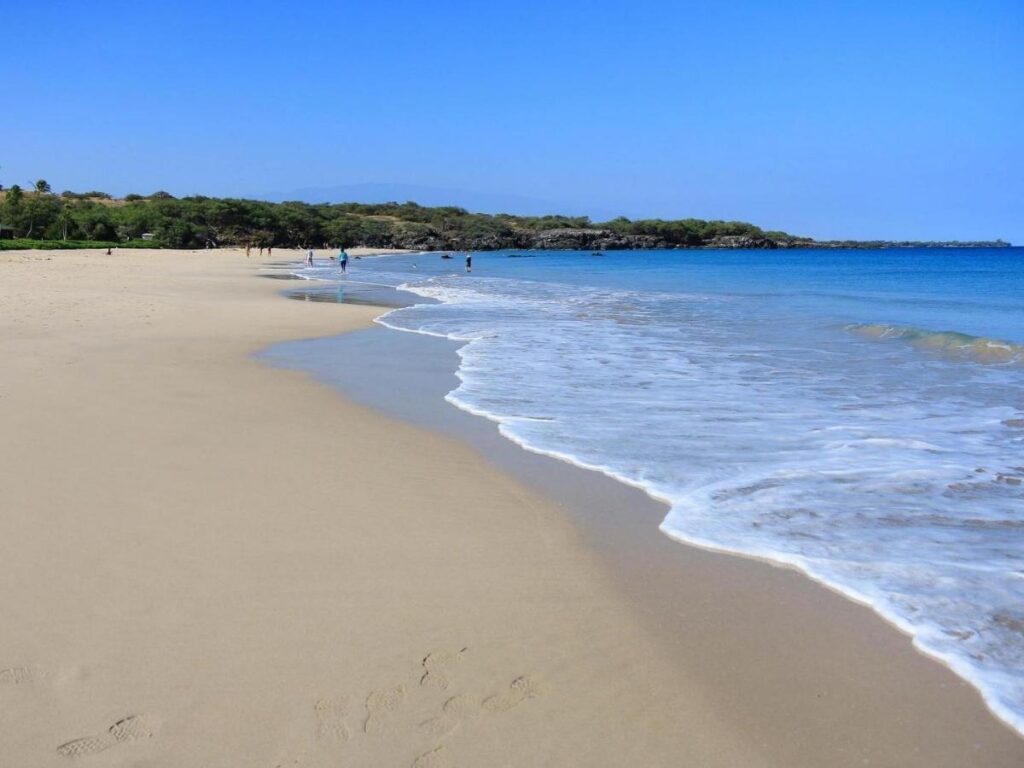 Wide white sand shoreline and calm turquoise water at Hapuna Beach on the Kona side of the Big Island