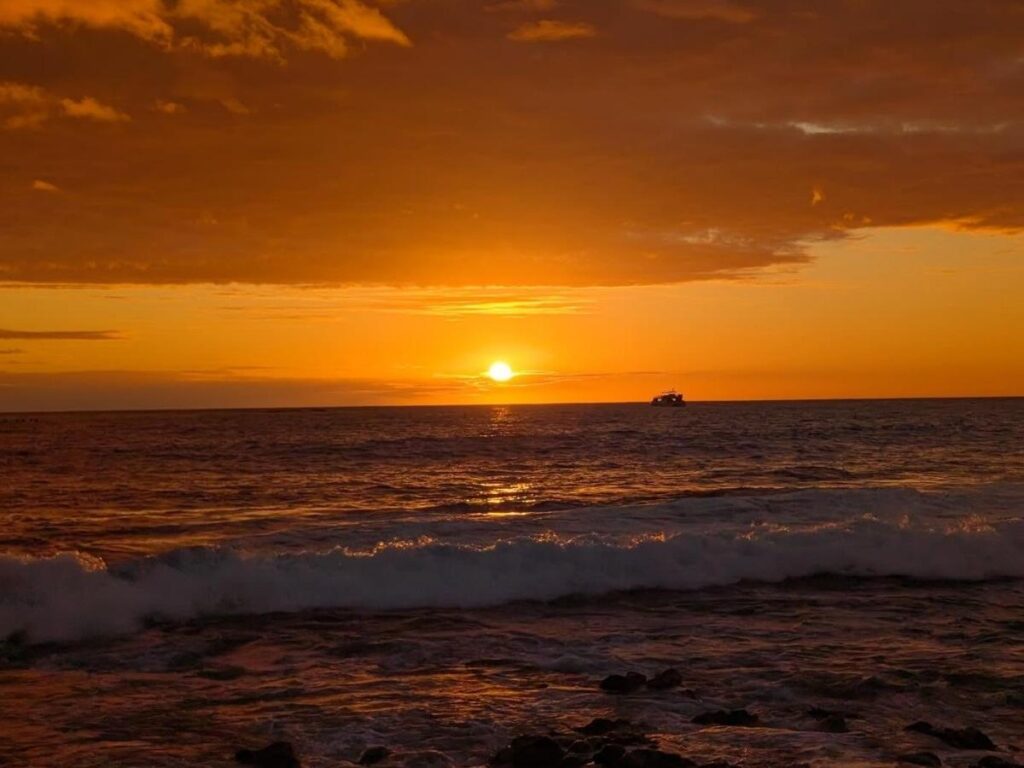 Sunset over the ocean at a beach in Hawaii with golden light on the waves