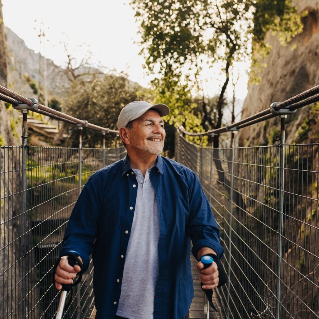 Older man stretching with trekking poles before a day hike