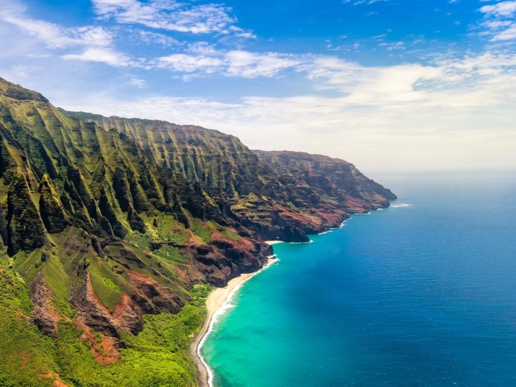Ke’e Beach at the start of the Na Pali Coast with clear water and mountain views