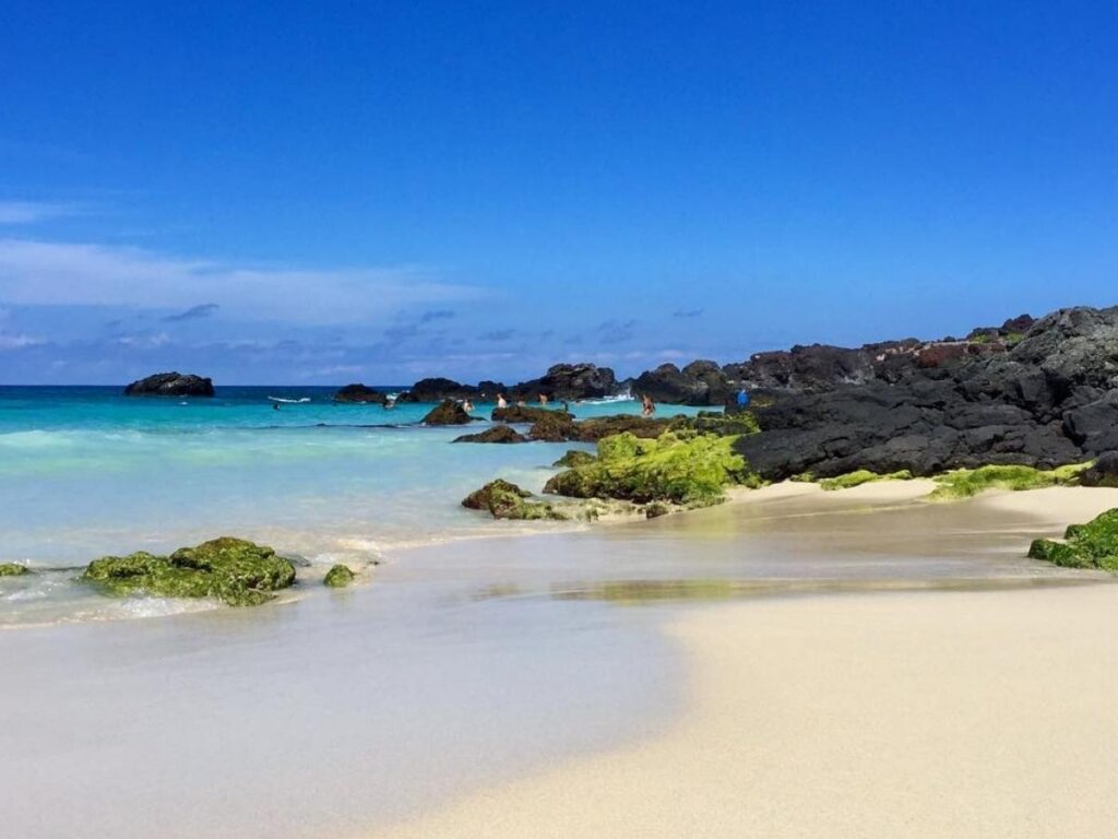 Lava rock coastline and sandy beach inside Kekaha Kai State Park on the Big Island