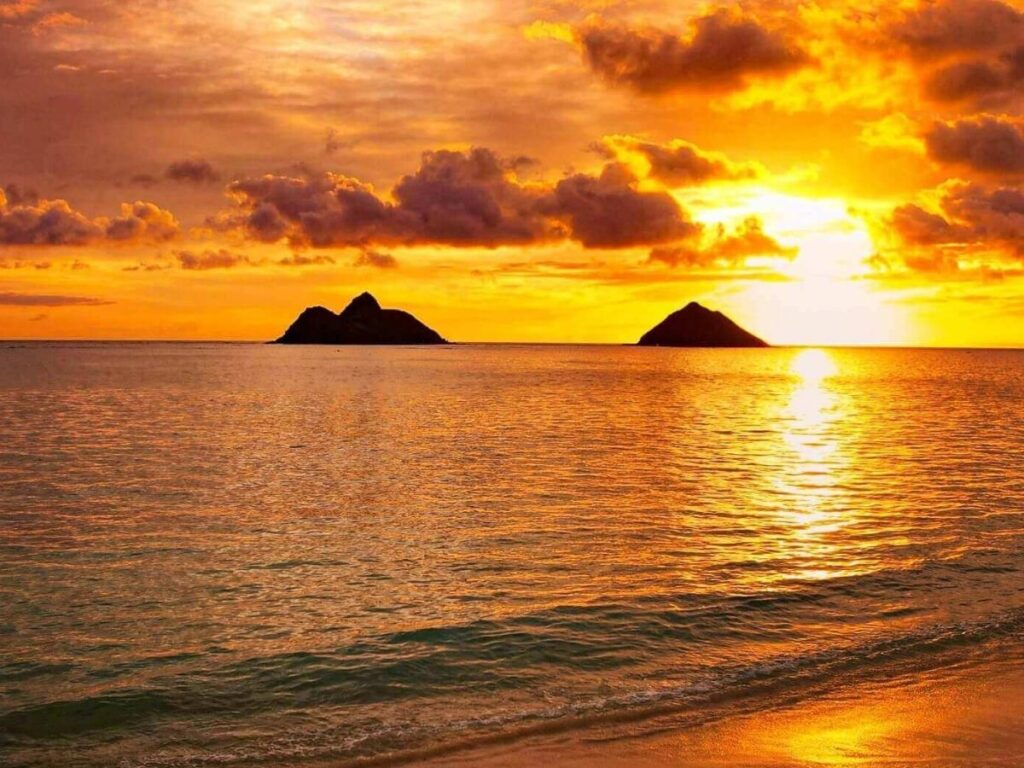 Sunrise at Lanikai Beach in Kailua Oahu with soft pink sky and the Mokulua Islands