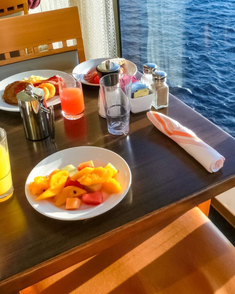 Cruise ship balcony suite with ocean view and breakfast setup