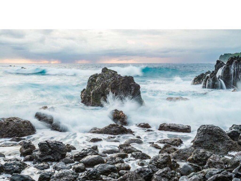 Waves crashing against dark lava rocks at Laupahoehoe Point