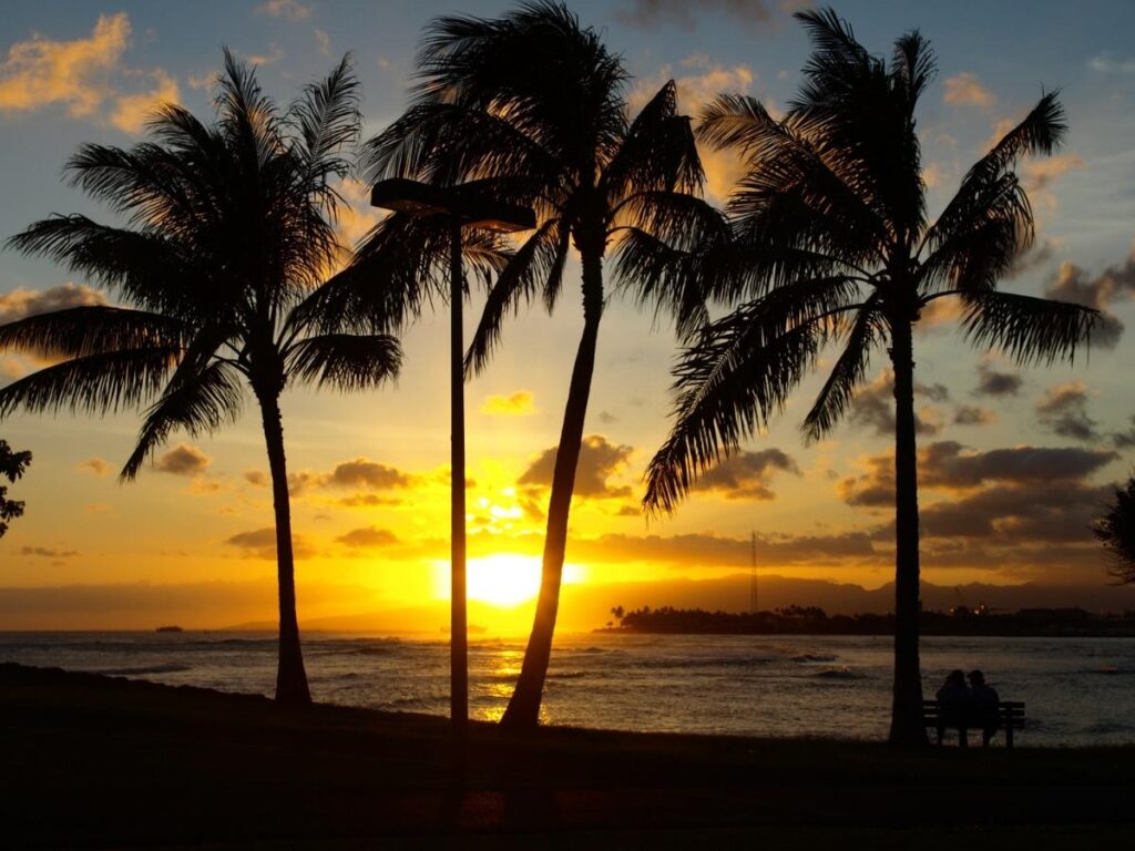 Sunset at Magic Island with Honolulu skyline and sailboats on the water