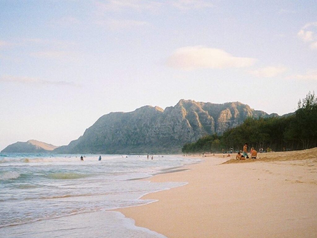 Makaha Beach in Waianae, Oahu with wide sandy shore and mountains behind