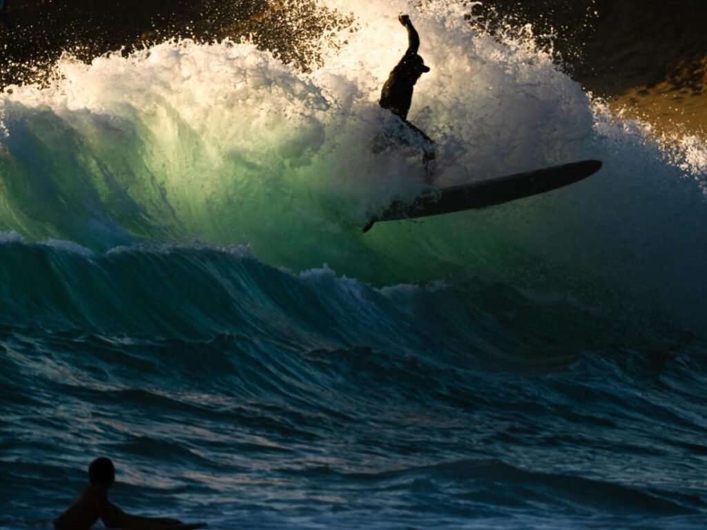 Surfer riding waves at Makaha Beach in Waianae, Oahu