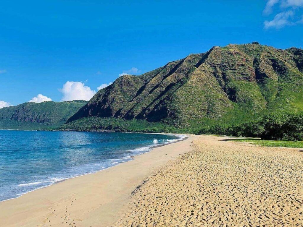 Makua Beach on Oahu’s west side with steep green mountains behind the sand