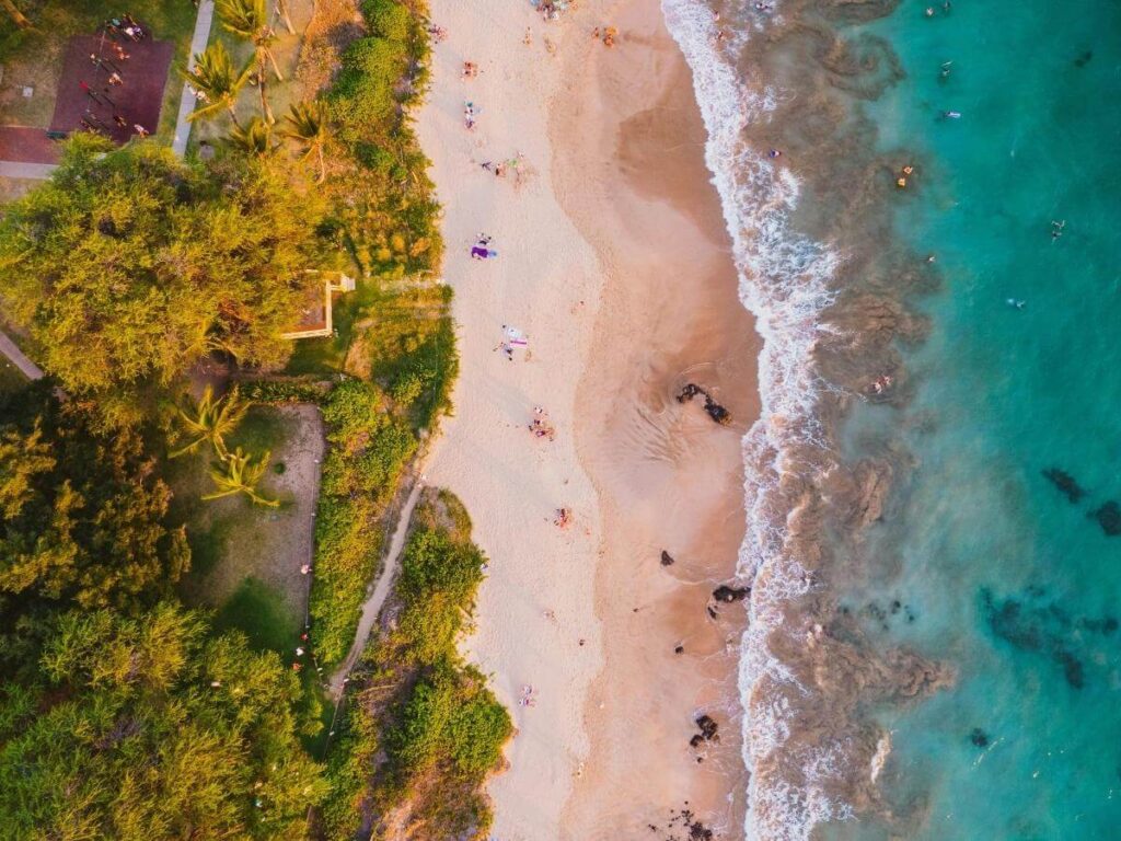 Golden sand beach in Maui with calm clear water along the coastline