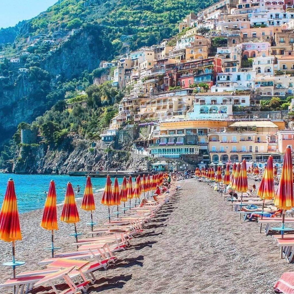 View of Positano from Spiaggia Grande with striped umbrellas on the beach