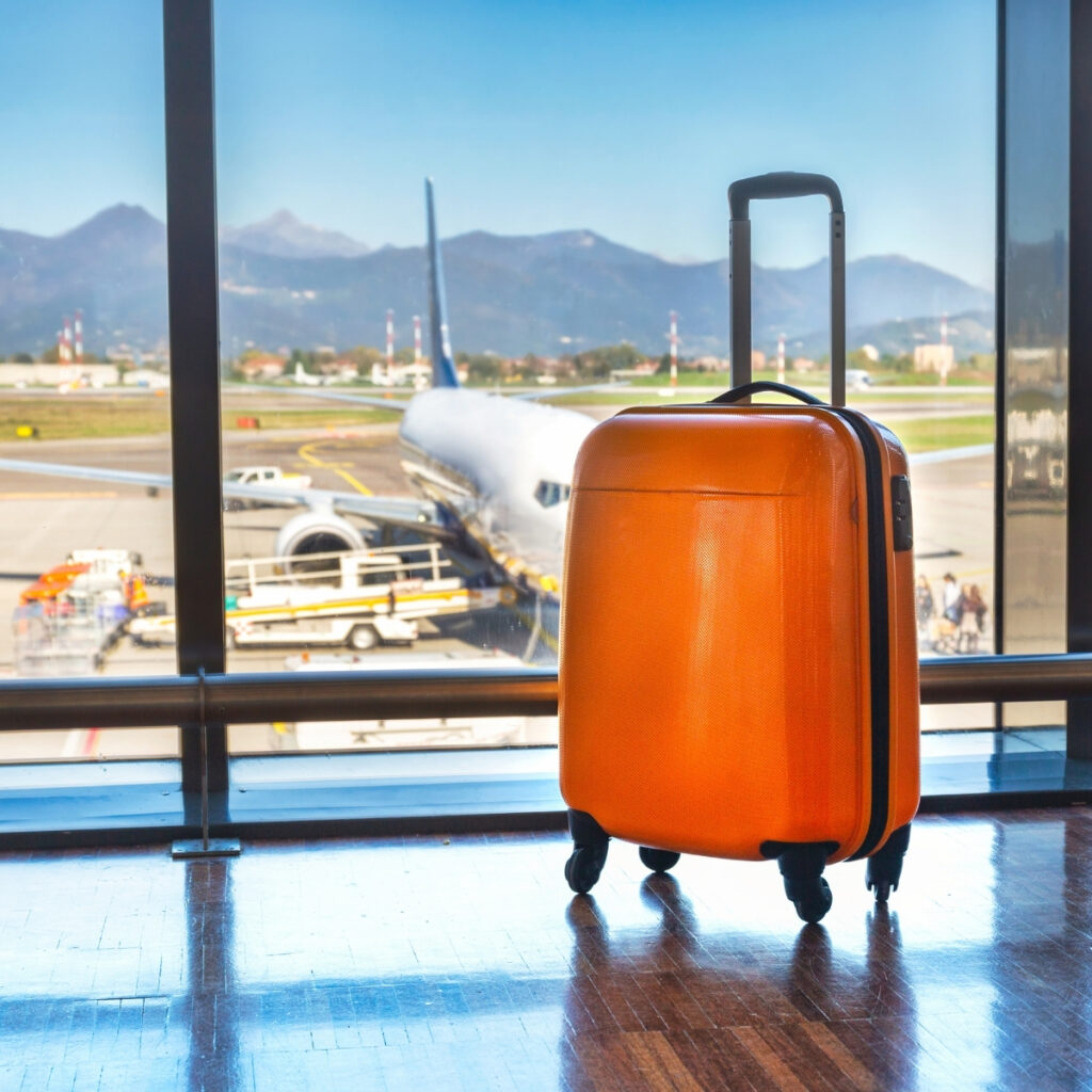 suitcase with visible wheels on an airport