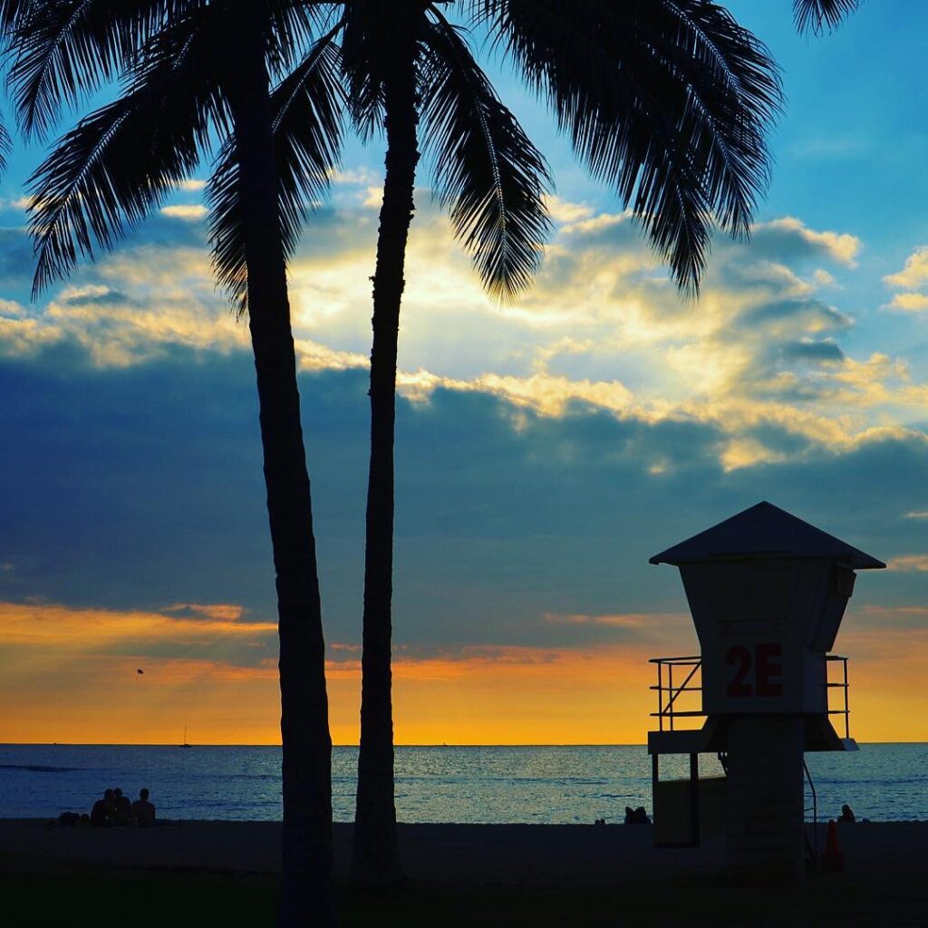 Sunset on Queen’s Surf Beach with people on shoreline