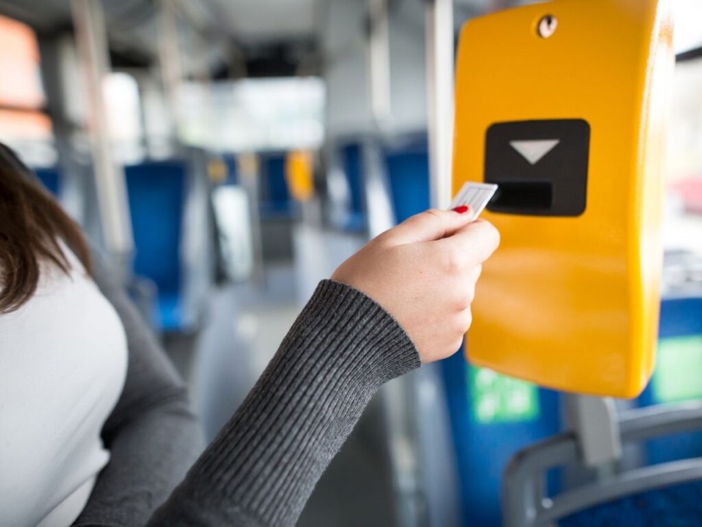 Hand placing ticket into a yellow validator machine