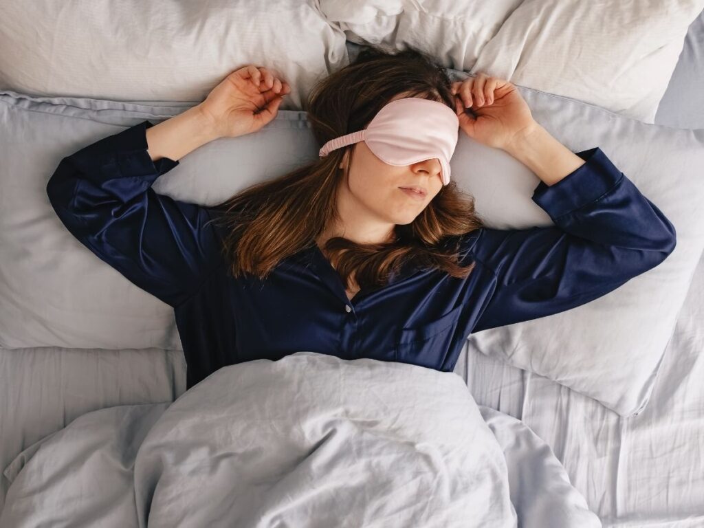 Cozy travel bedroom with soft lighting, an eye mask on the nightstand, and a peaceful vibe