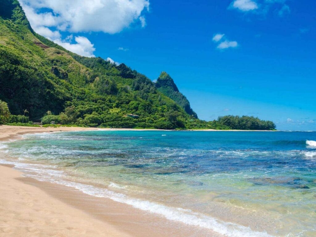 Tunnels Beach on Kauai with reef formations and mountains in the background