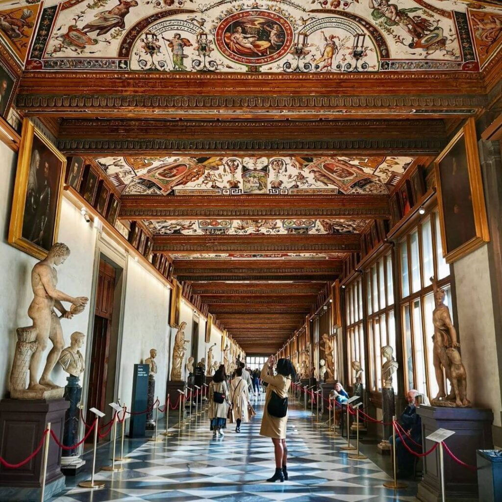 Inside Uffizi Gallery with Renaissance paintings and arched ceilings