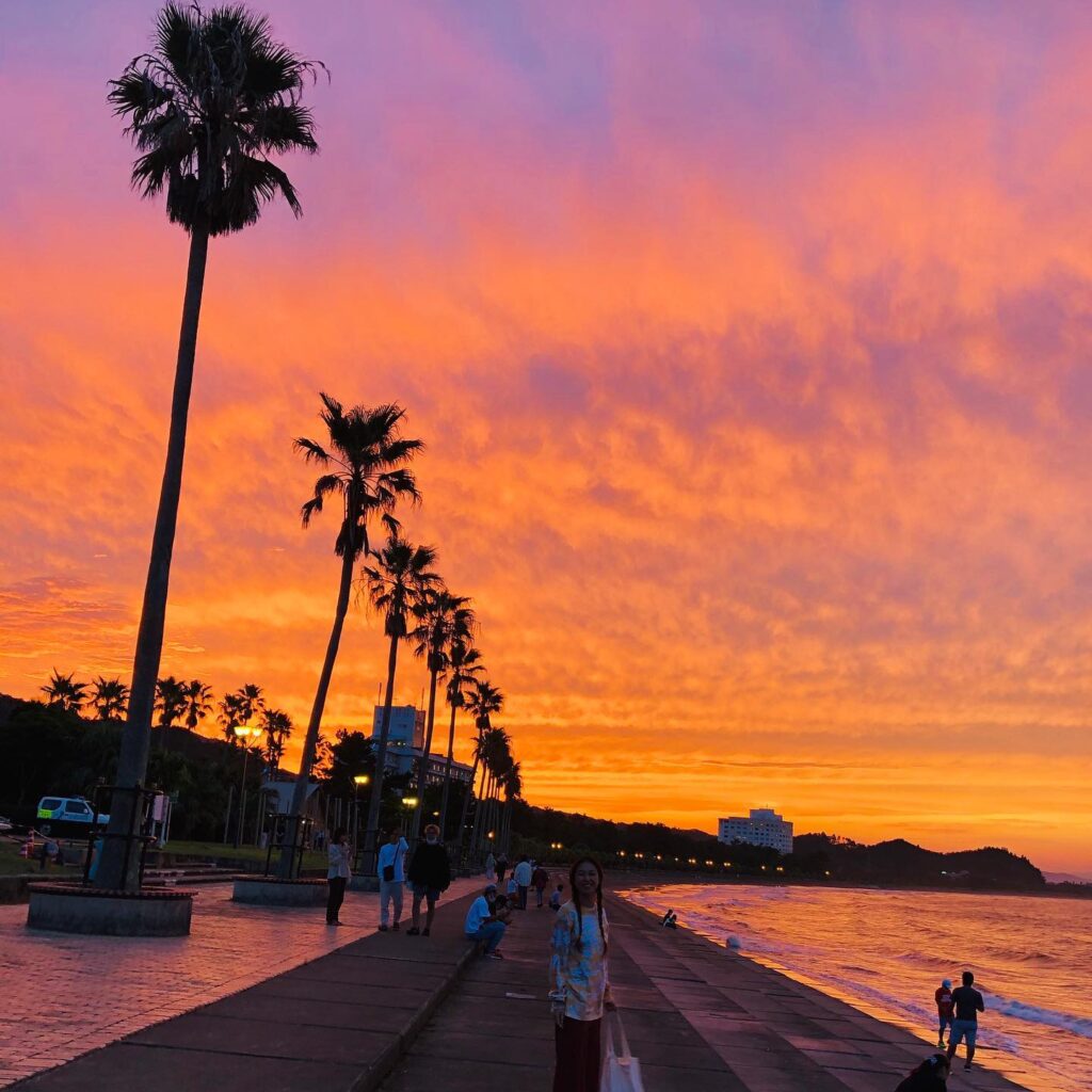Visitors enjoying the colorful afterglow at Waikiki Beach after sunset