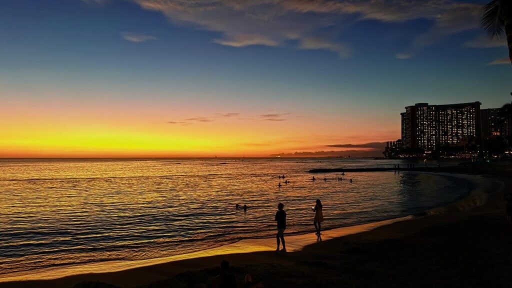 beachgoers enjoying sunset at Waikiki Beach