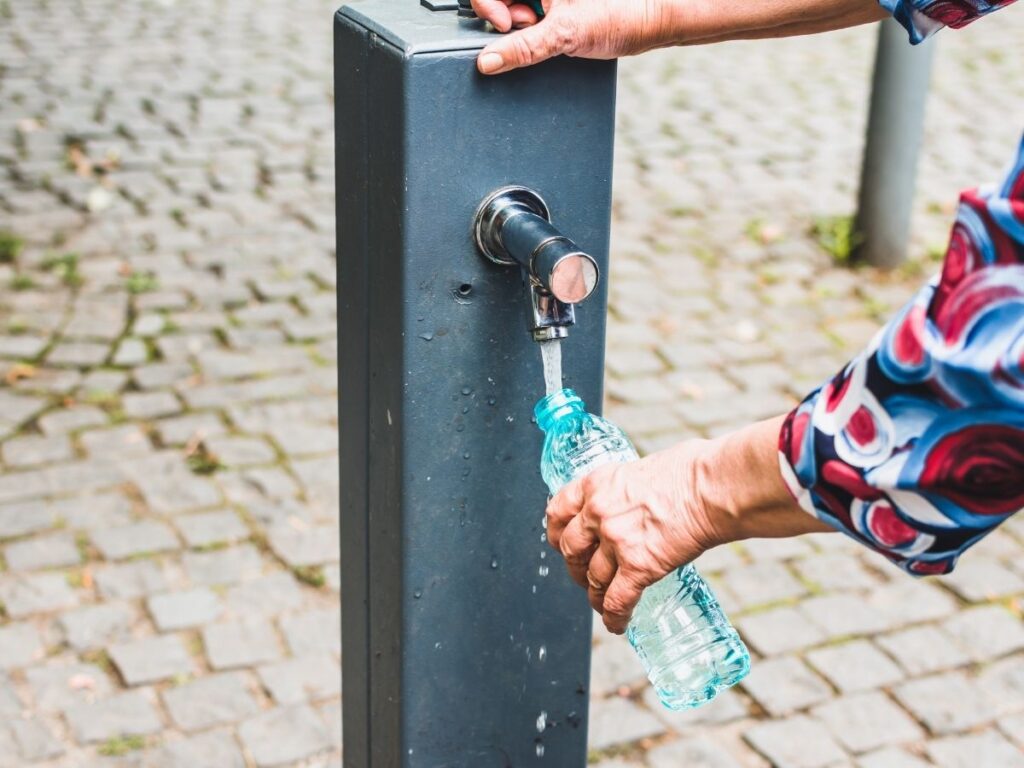 Refilling a travel bottle to avoid spending on bottled water