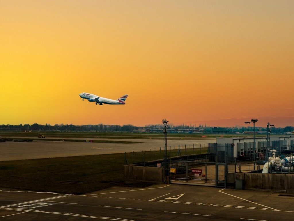 Airplane taking off at sunset, symbolizing travel hacks for cheaper flights.