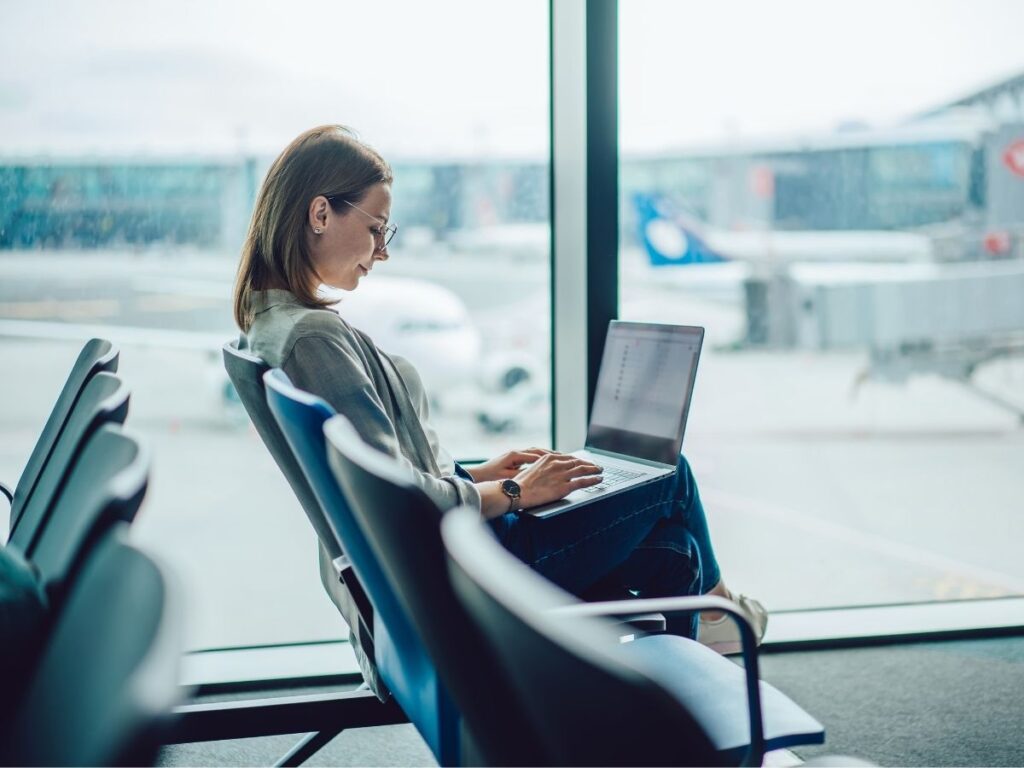 Traveler using laptop with free WiFi at airport terminal