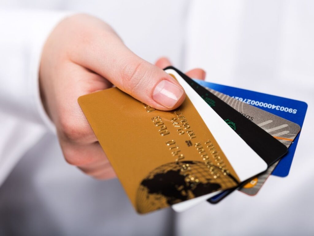 Close-up of hands holding multiple travel reward credit cards