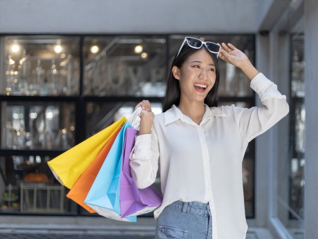 Passenger walking through airport with duty-free shopping bag.