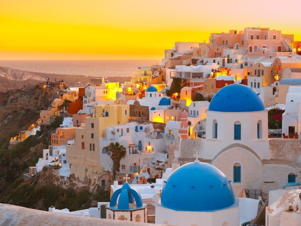 Whitewashed buildings and blue domes of Oia, Santorini at sunset