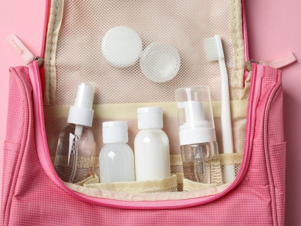 Travel-sized wipes, toothbrush, moisturizer, and deodorant arranged for freshening up during a long flight.