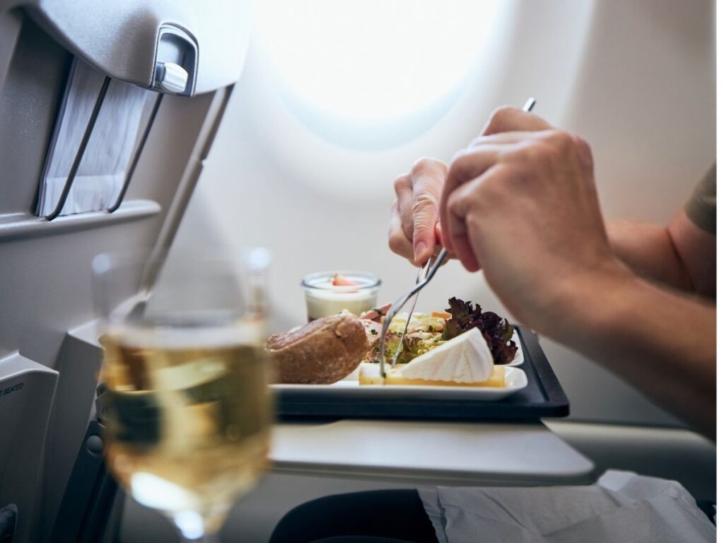 Budget-friendly in-flight meal served on a tray table next to airplane window