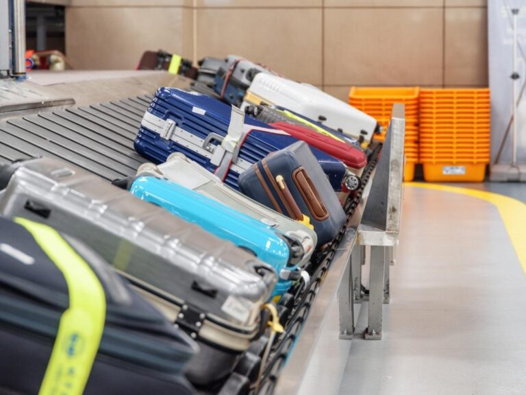 A busy airport baggage carousel filled with colorful suitcases