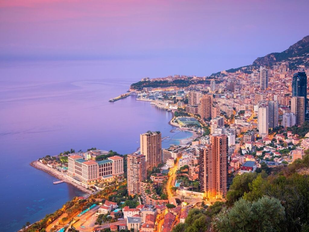 Aerial view of Monte Carlo harbor in Monaco with luxury yachts and city skyline.