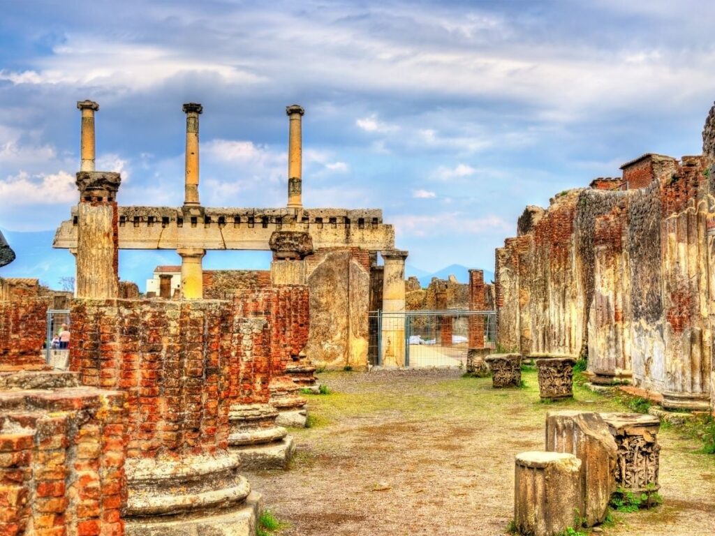 Ancient Forum ruins in Pompeii framed by standing columns.