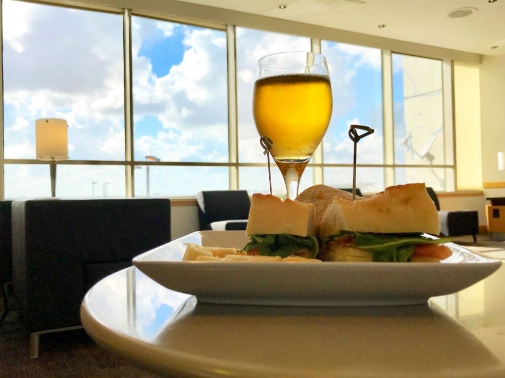 Quiet airport lounge with buffet, work tables, and window views