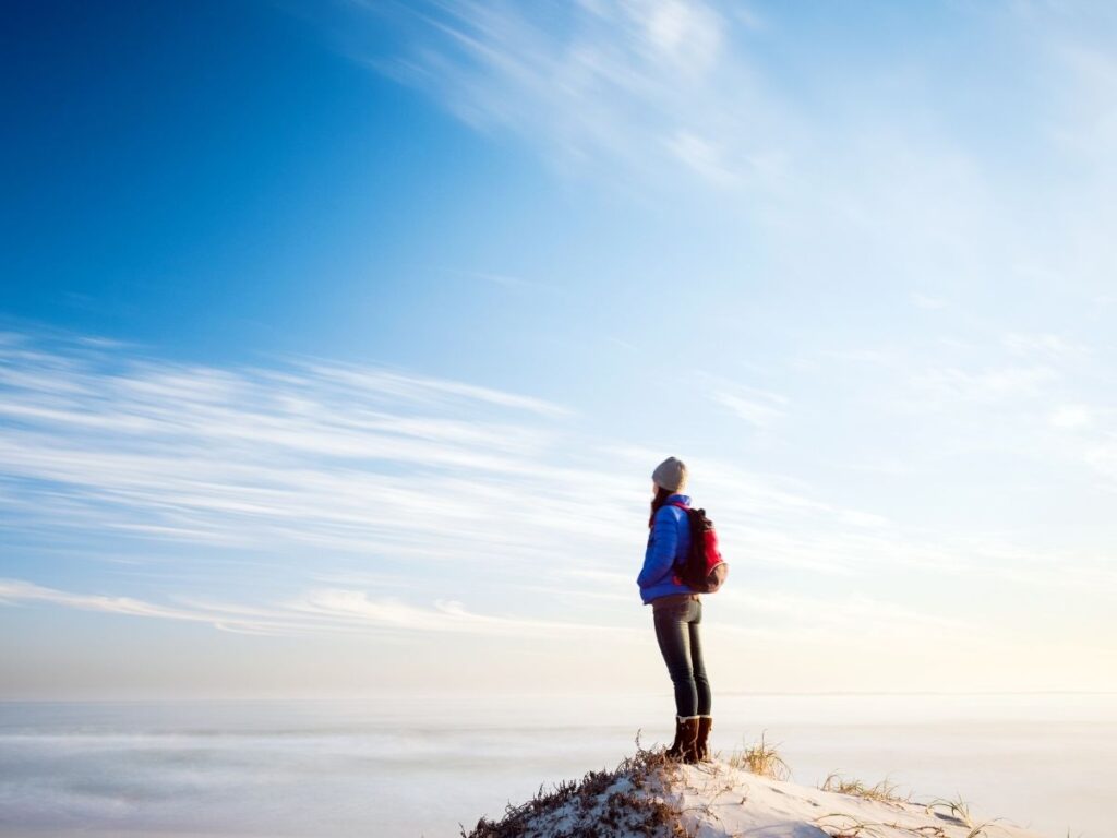 Female solo traveler hiking along a trail