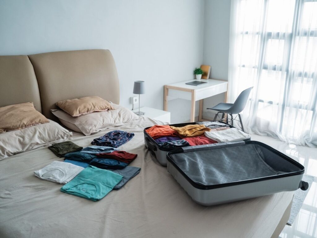 Complete travel outfits laid out on a bed