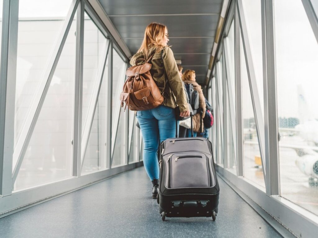 Traveler wearing layers and boots to save space in carry-on luggage