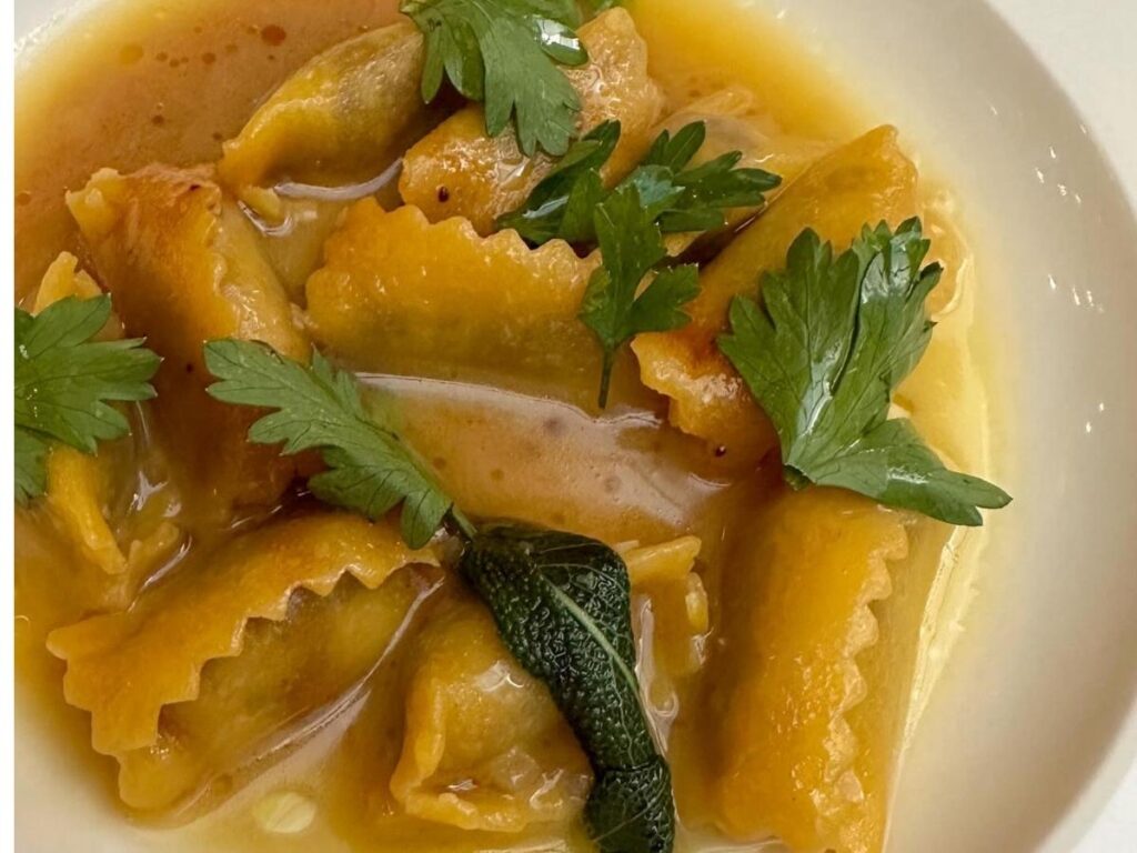 Close-up of agnolotti del plin pasta with butter and sage in Monforte d’Alba