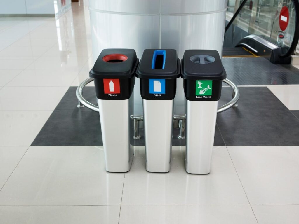 Discarded boarding passes and luggage tags in airport trash can.