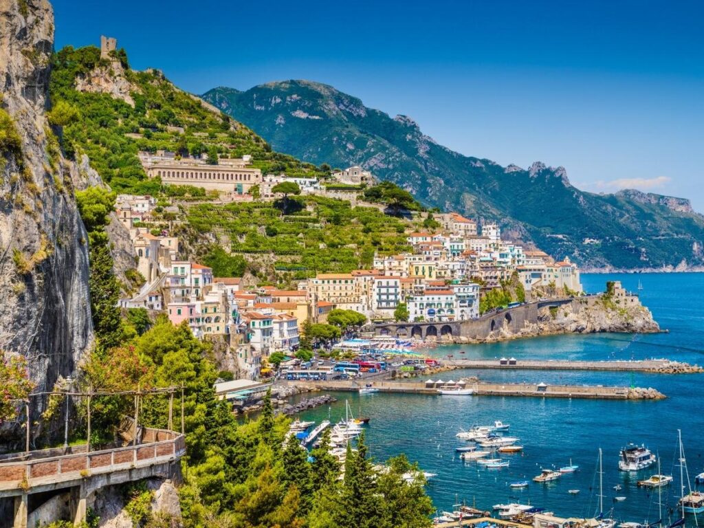 Amalfi Coast view from a hotel balcony with coffee cups on the railing.