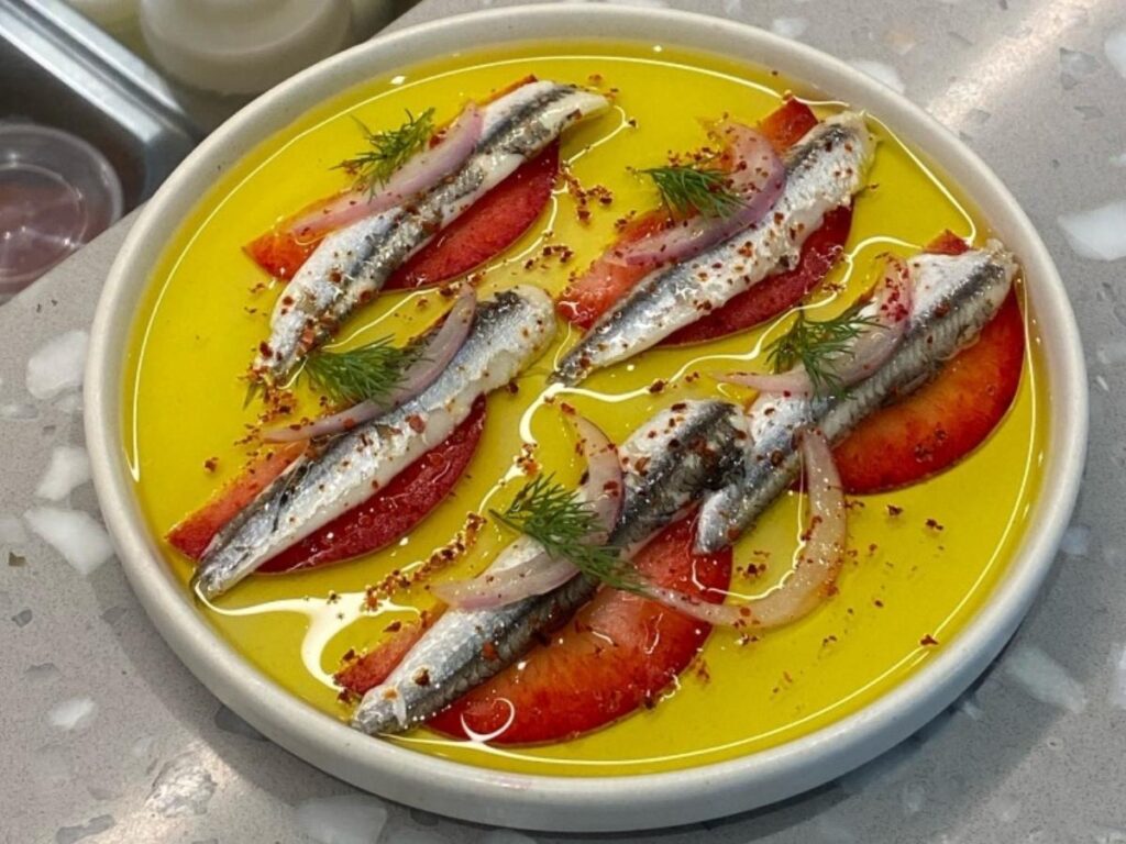 Plate of fresh anchovies prepared three ways—fried, marinated, and baked—served in Monterosso.