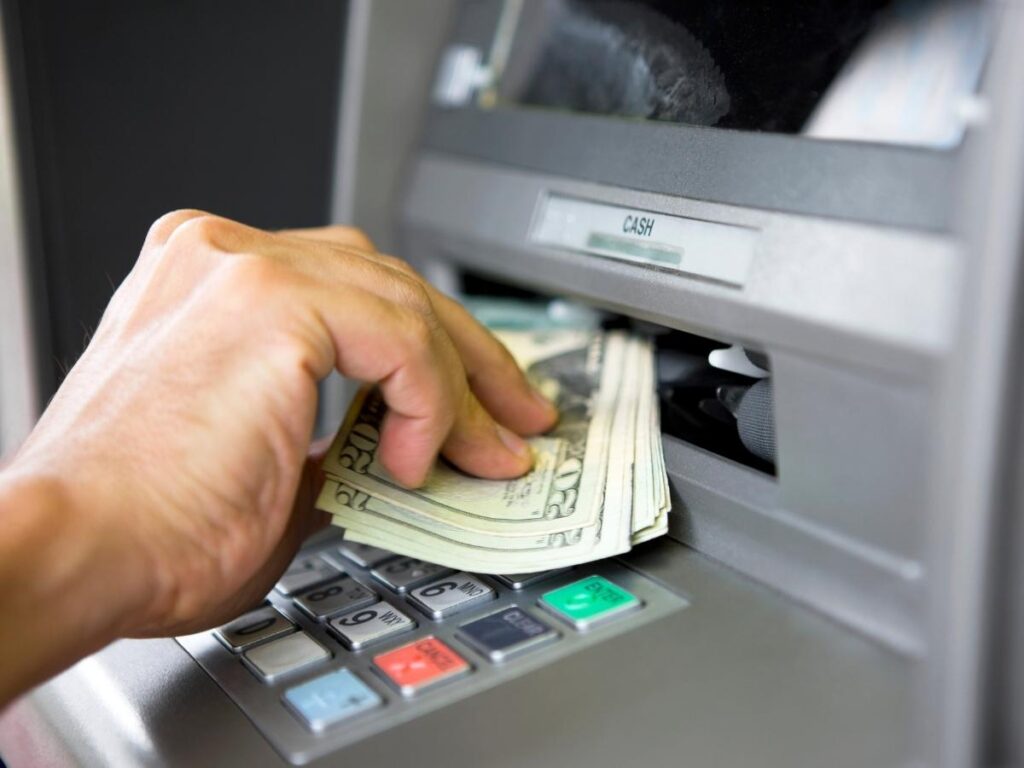 Traveler withdrawing money from a bank ATM abroad