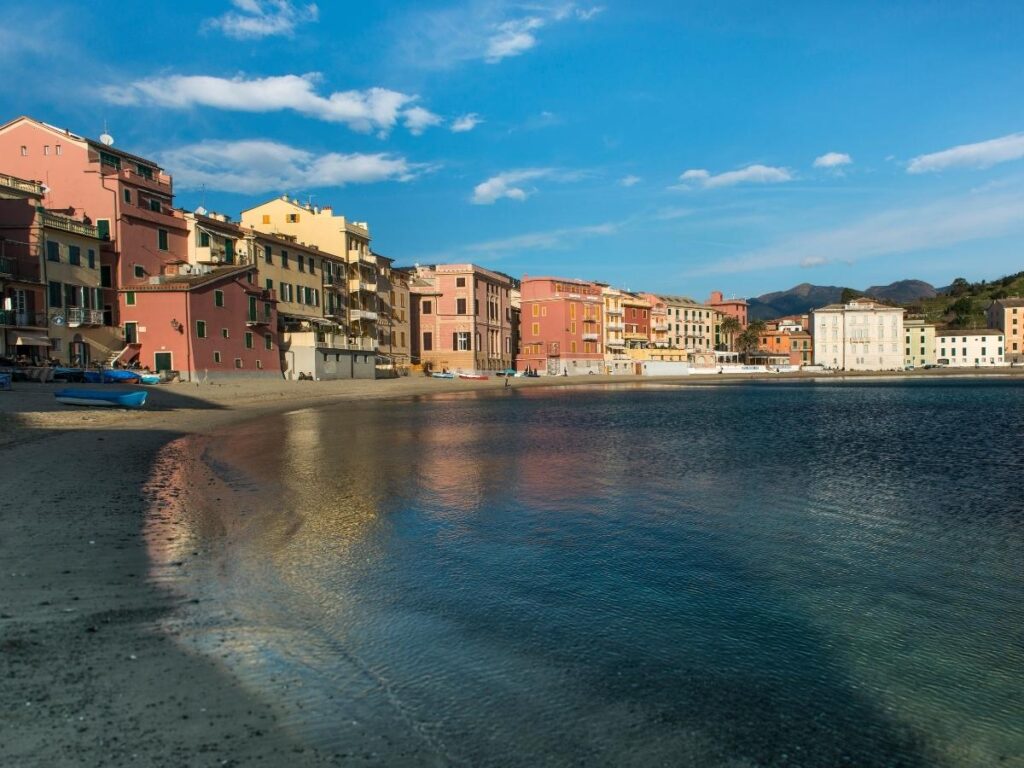 Early morning reflections at Baia del Silenzio with pastel houses mirrored on calm water.