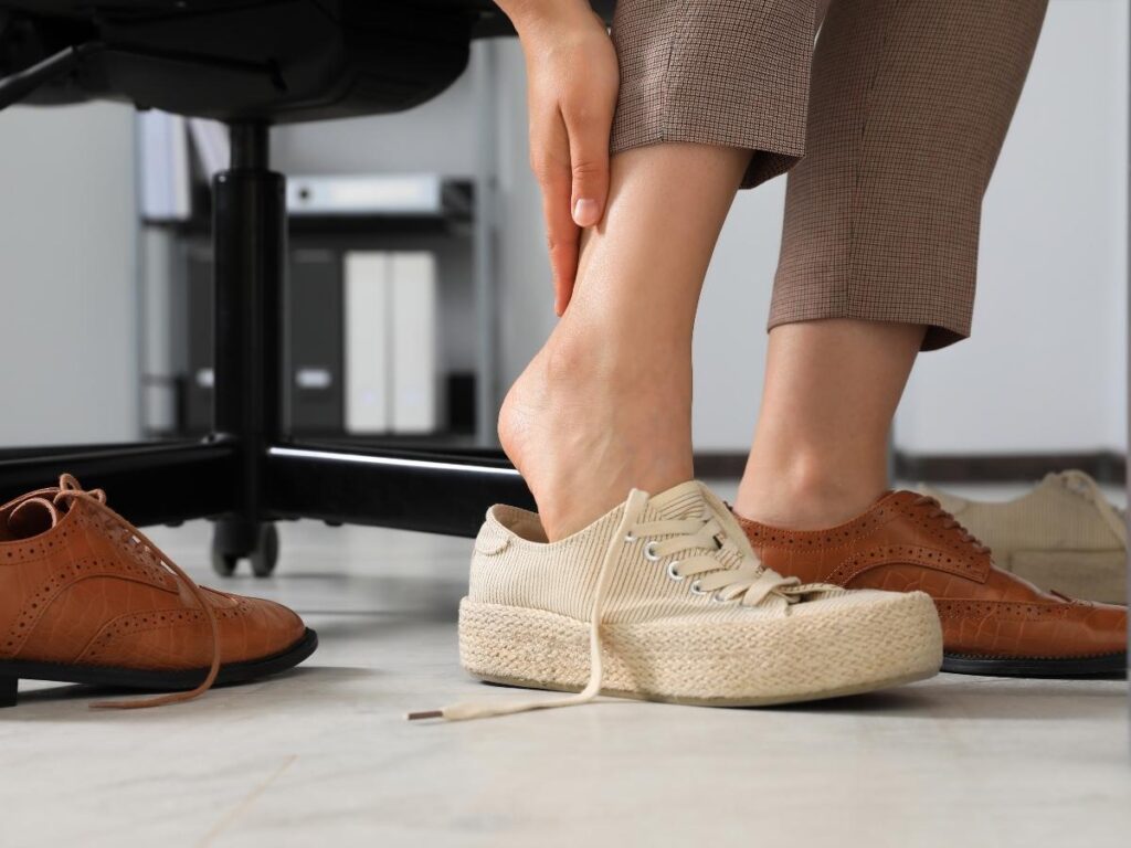 Traveler taking off painful new shoes during a city walk
