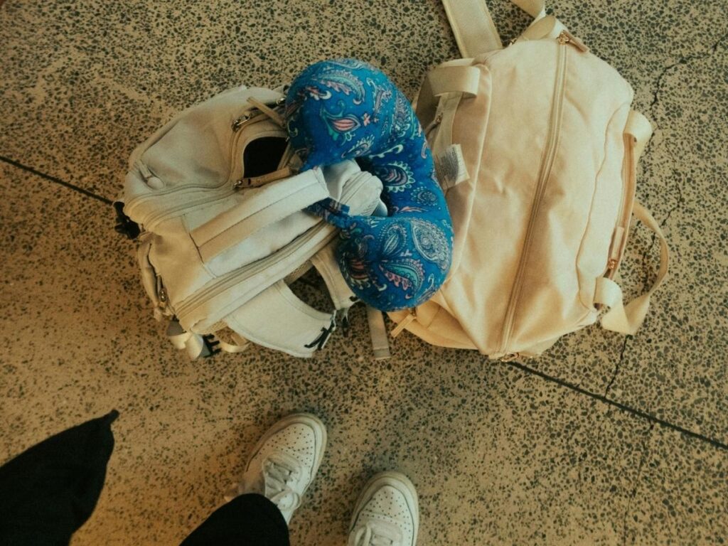 Oversized neck pillow awkwardly hanging off backpack, wasting space