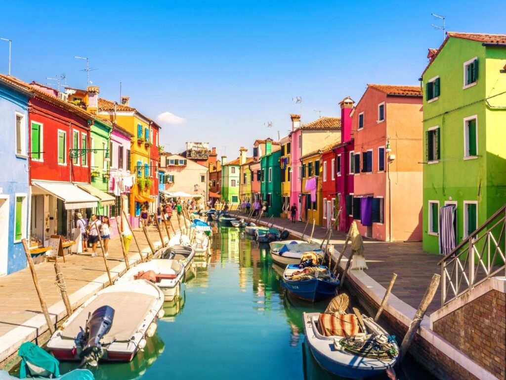 Brightly painted houses reflected in the canals of Burano